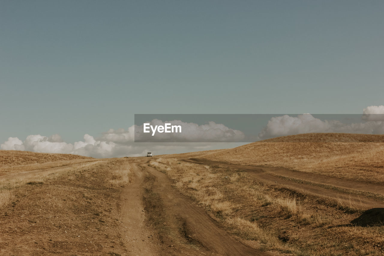 SCENIC VIEW OF ROAD AMIDST LAND AGAINST SKY