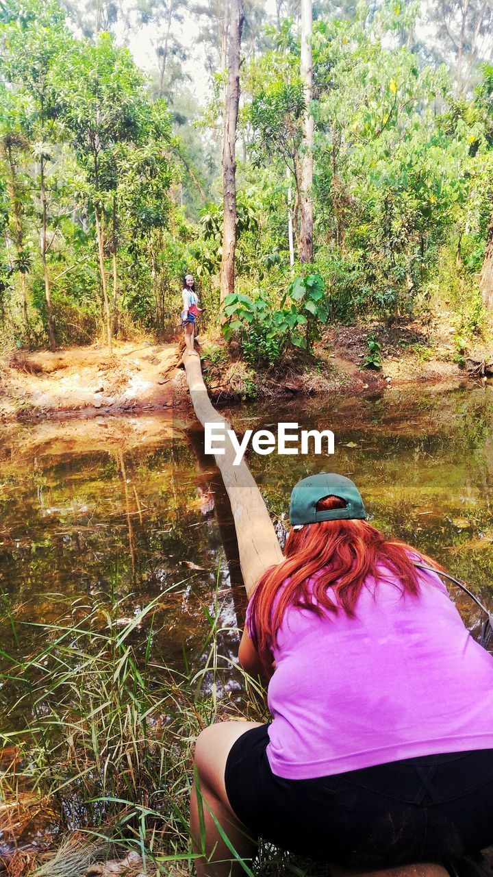 WOMAN STANDING ON GRASS IN FOREST