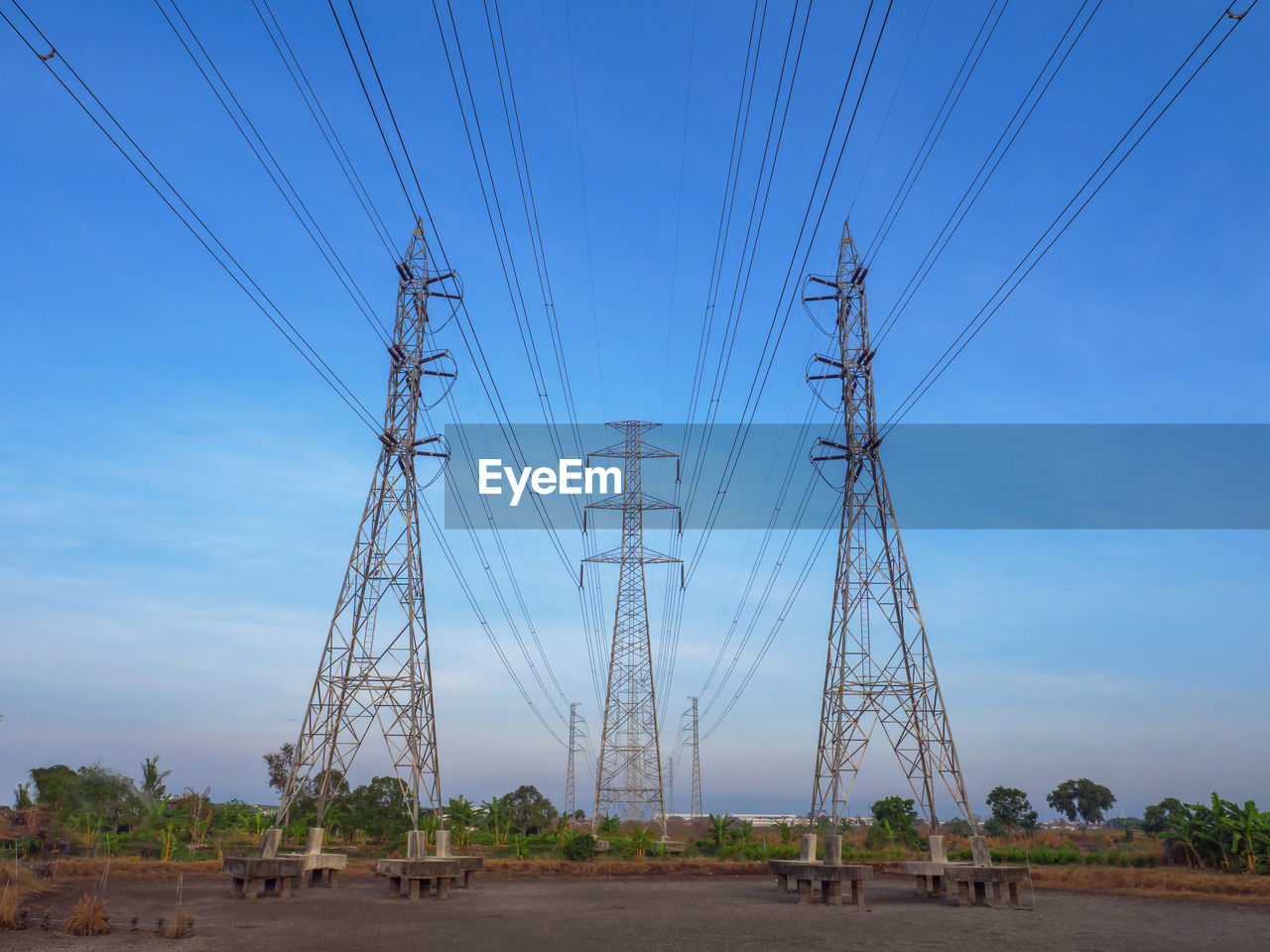 High voltage transmission towers with electricity power line over blue sky and white cloud
