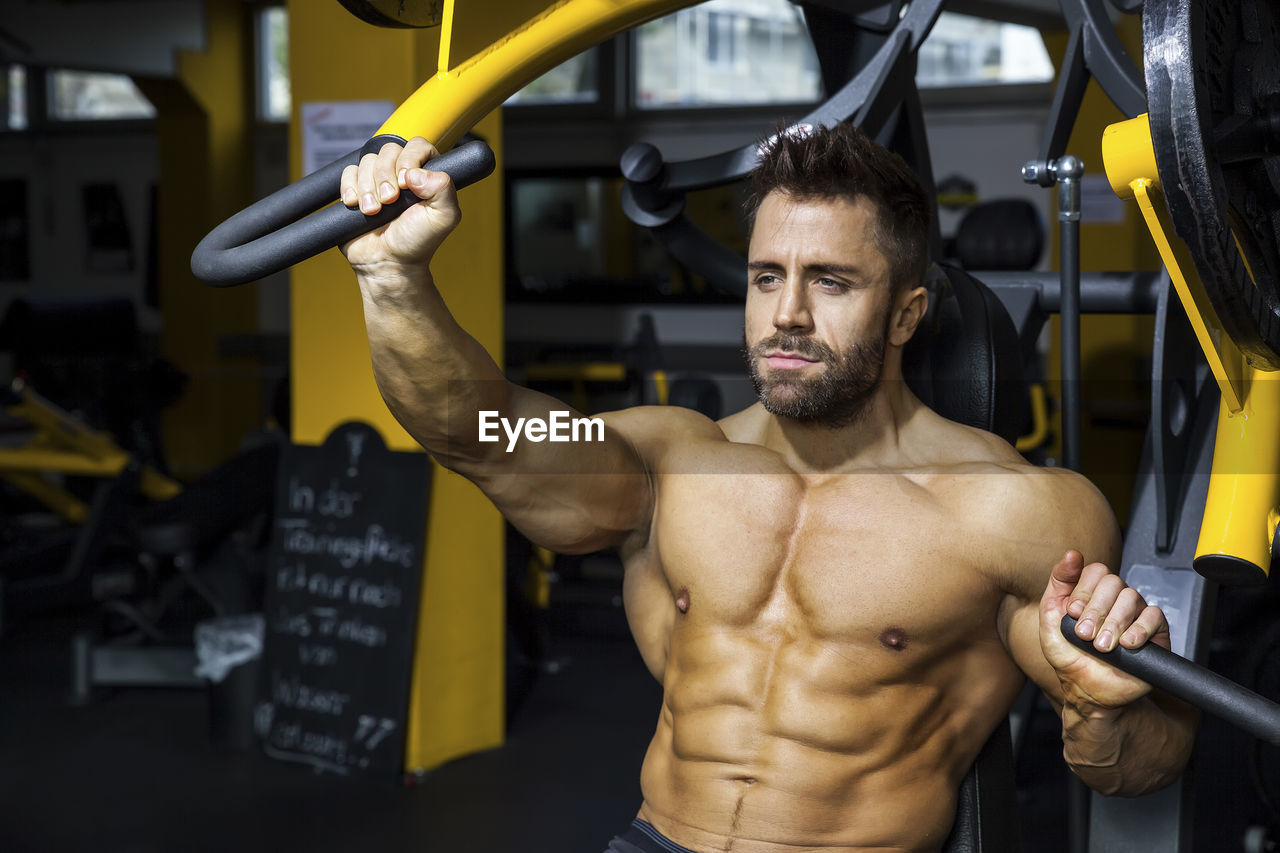 Man exercising on equipment at gym