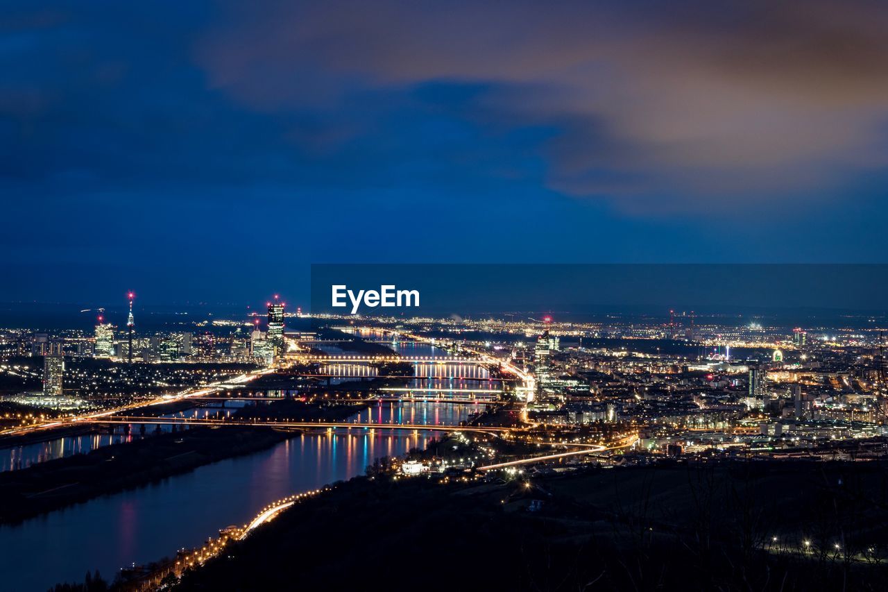 ILLUMINATED CITY AGAINST CLOUDY SKY