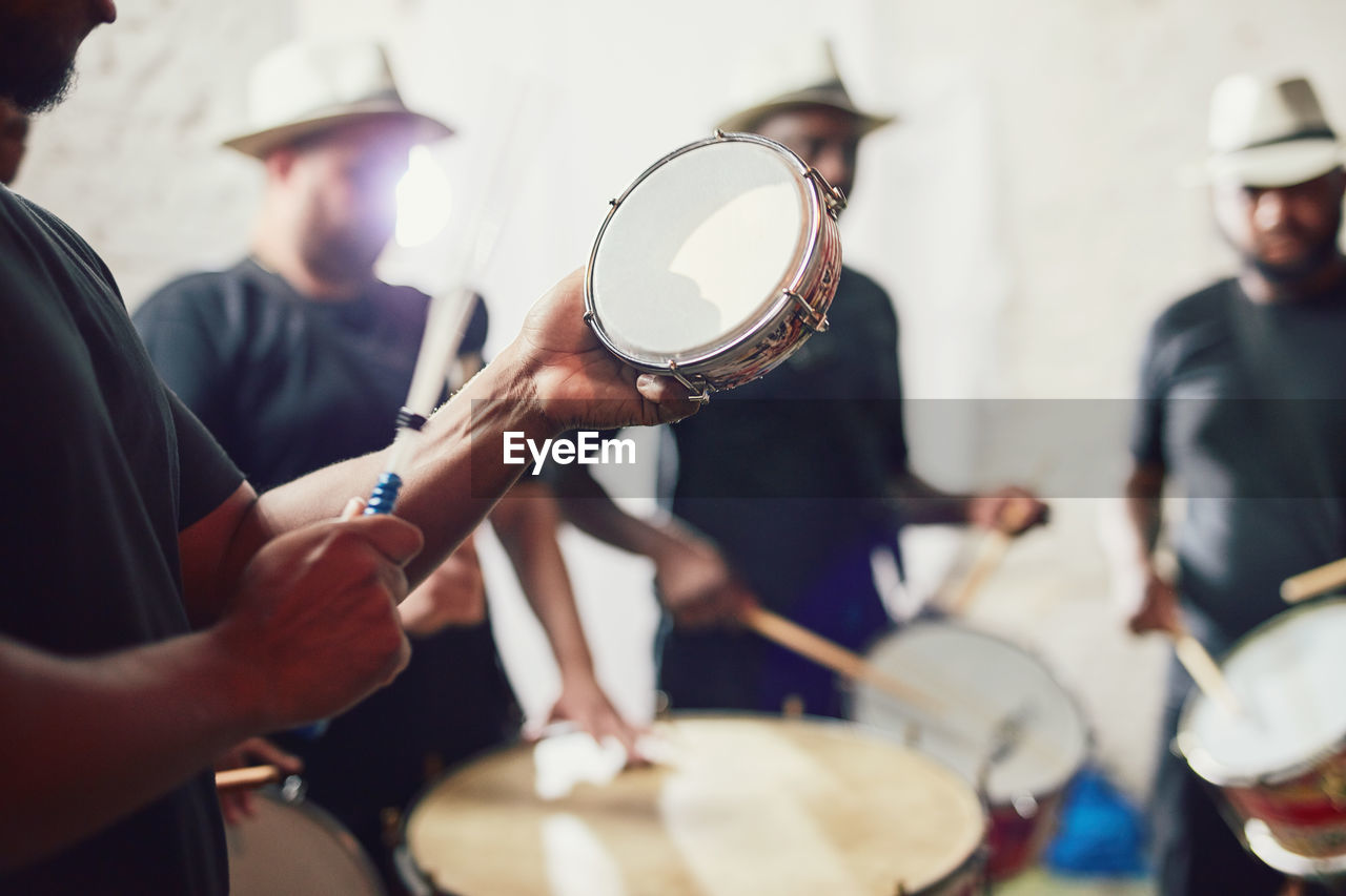 Midsection of man playing drum