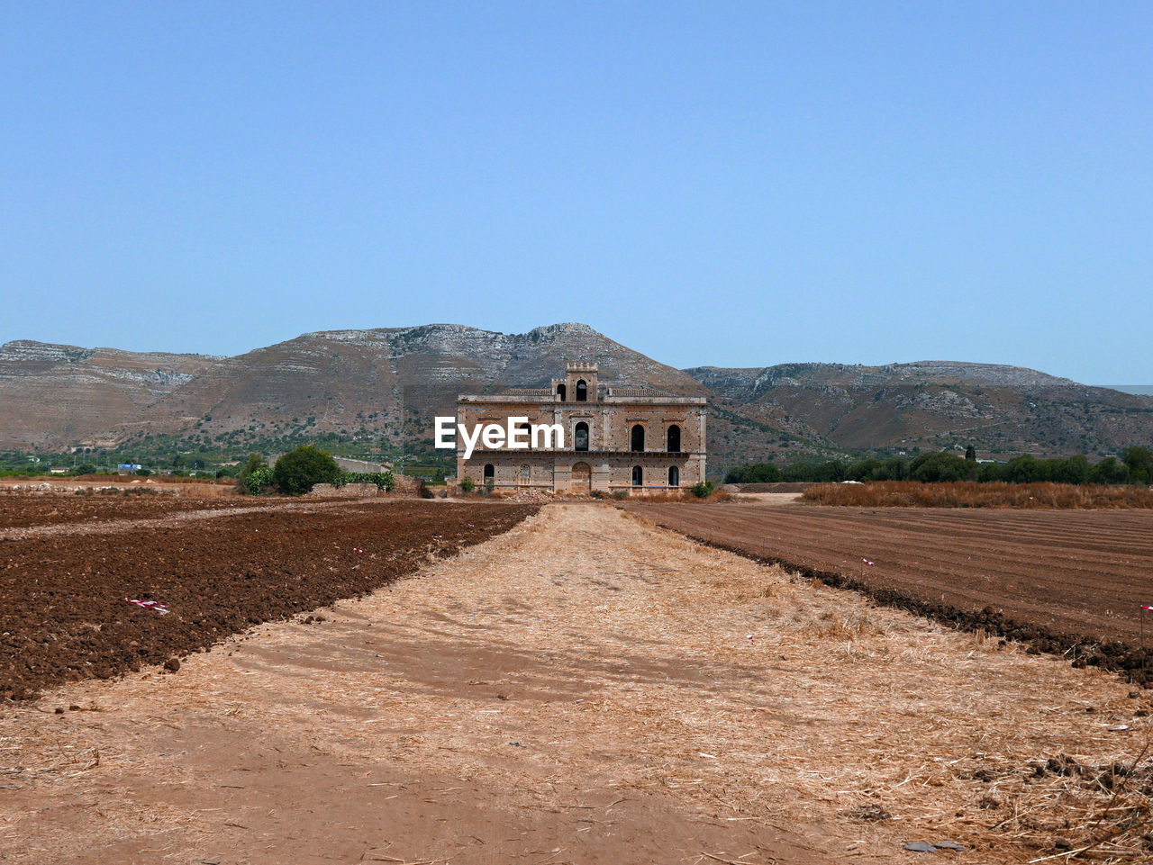 Evocative image of an abandoned farmhouse in the arid sicilian countryside