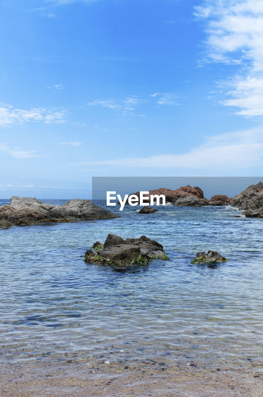 Rocks in sea against sky