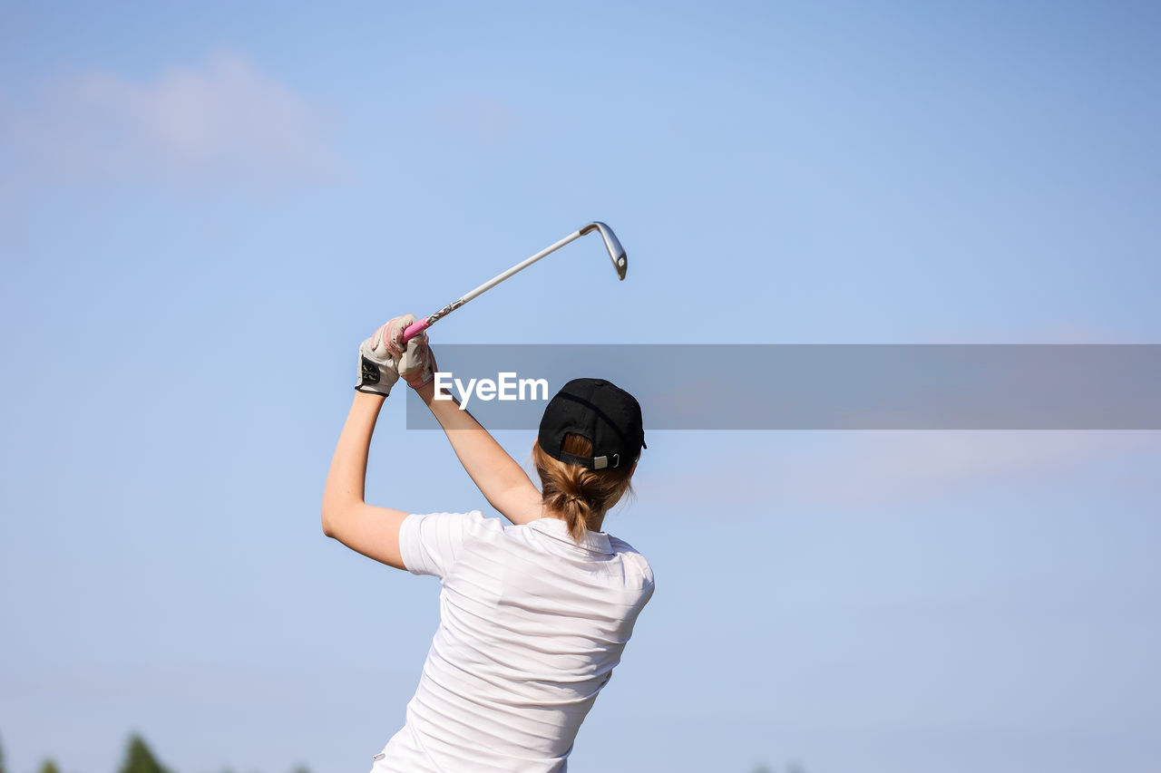 REAR VIEW OF WOMAN STANDING WITH UMBRELLA