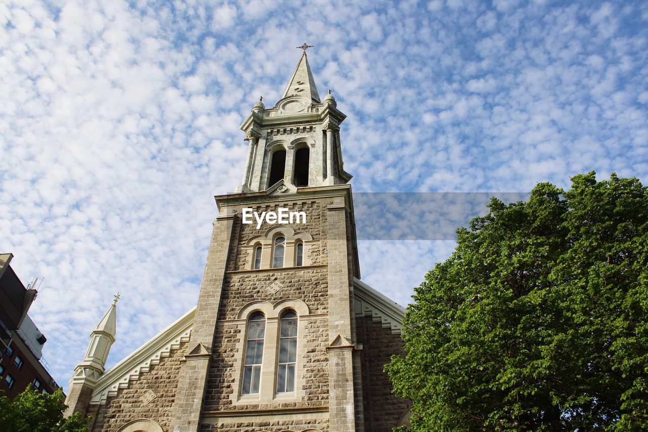 Low angle view of building and trees against sky