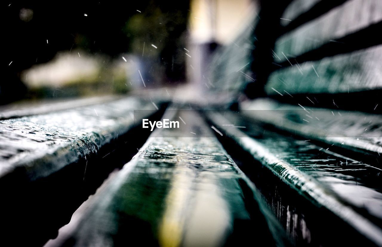 Close-up of raindrops on wooden bench