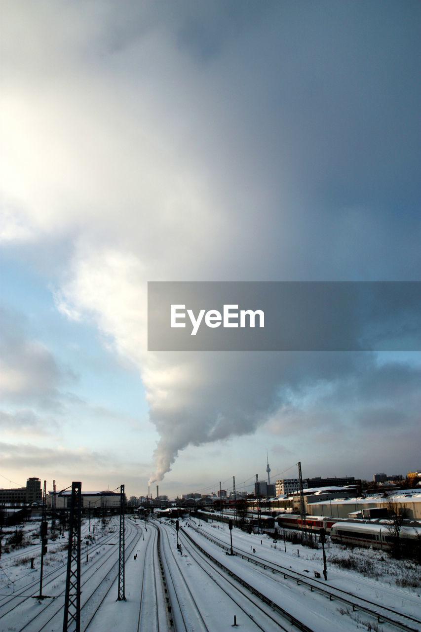 View of railroad tracks against cloudy sky during winter