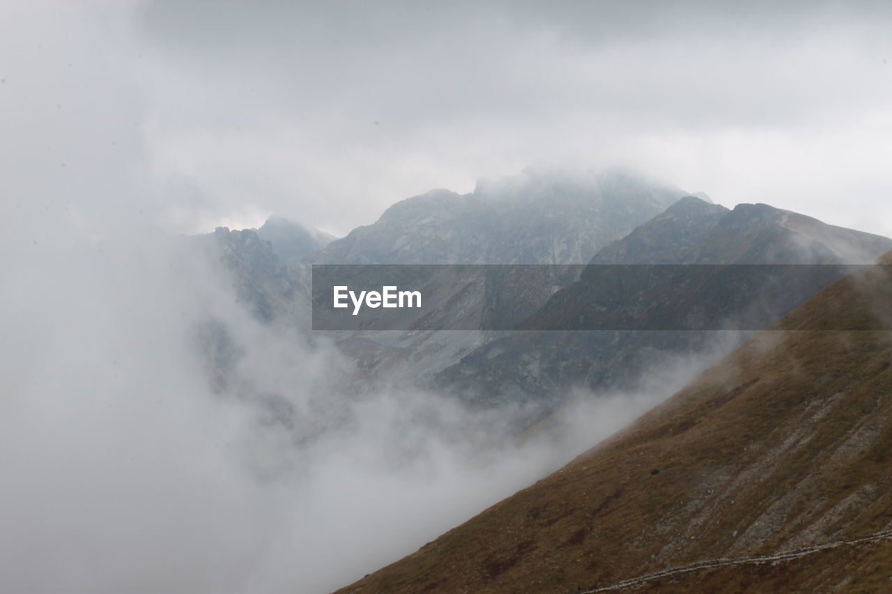 High angle view of mountain range against sky in foggy weather