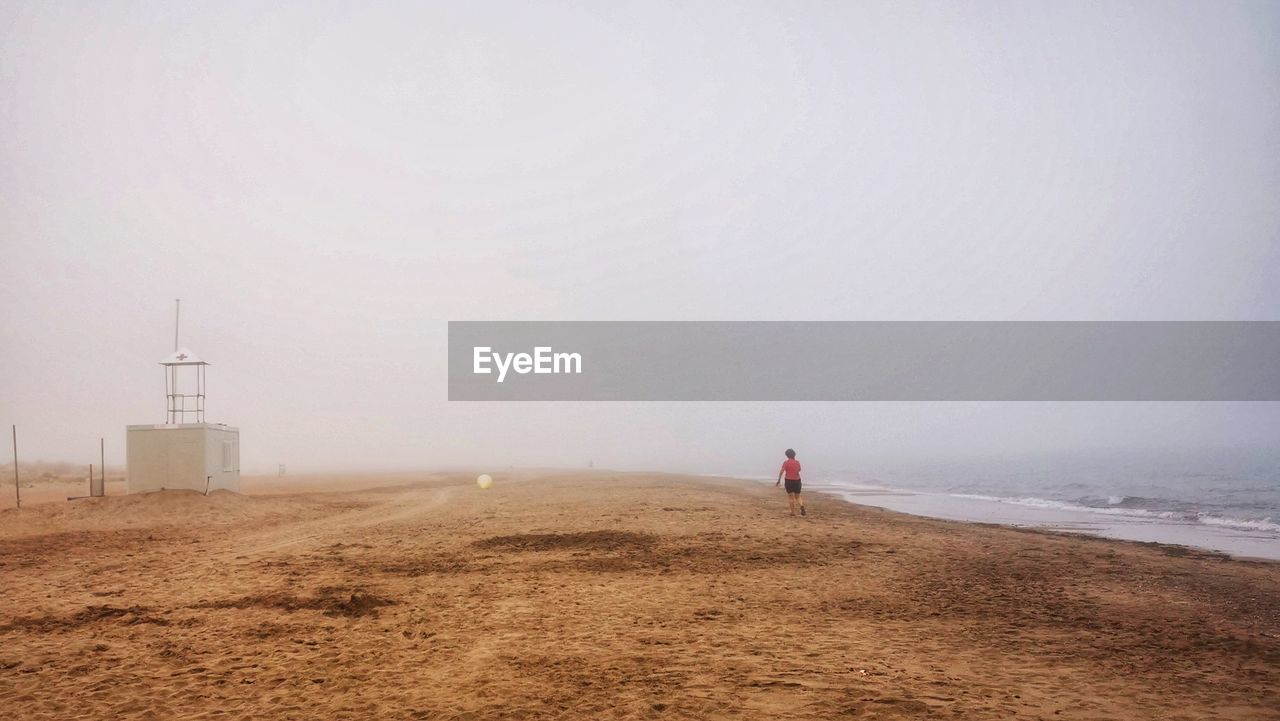 Rear view of woman walking on beach