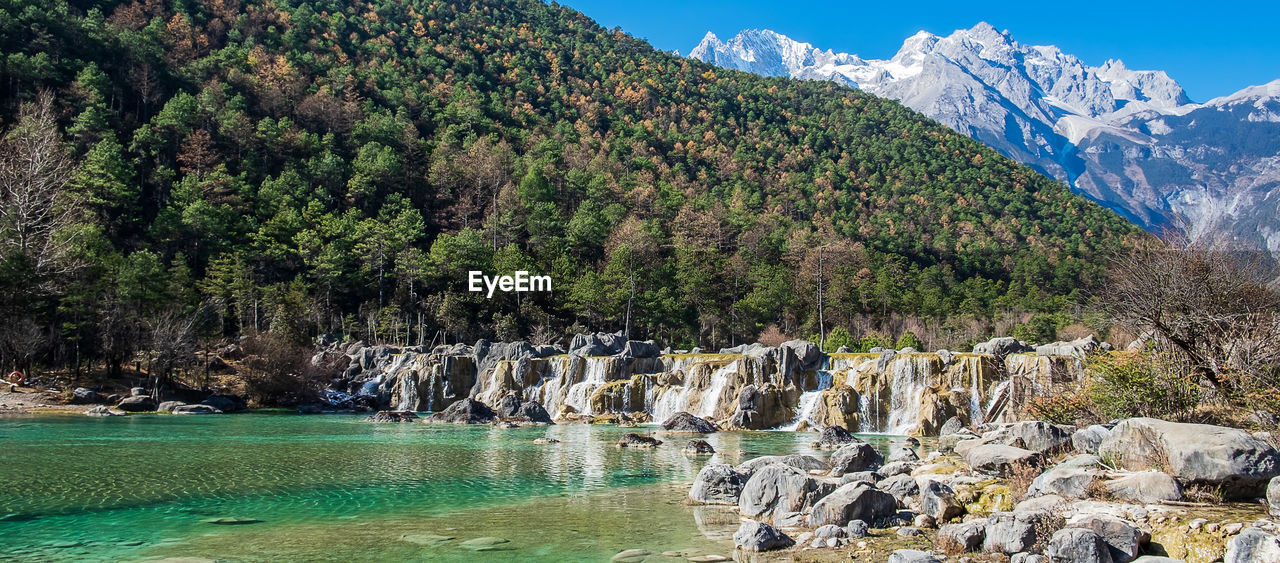 SCENIC VIEW OF SEA AGAINST MOUNTAINS