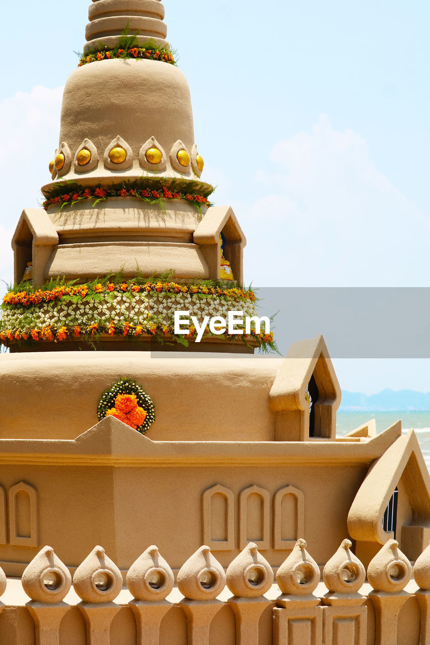 LOW ANGLE VIEW OF TEMPLE AGAINST BUILDING AGAINST SKY