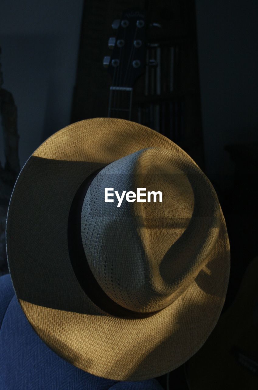 HIGH ANGLE VIEW OF HAT ON TABLE IN SUNLIGHT