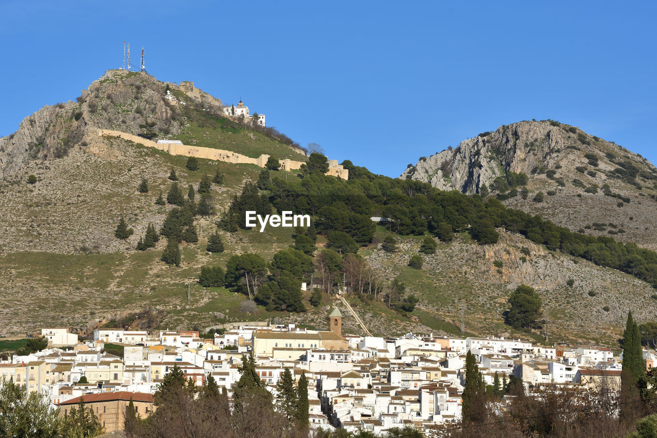 Houses on mountain against clear sky