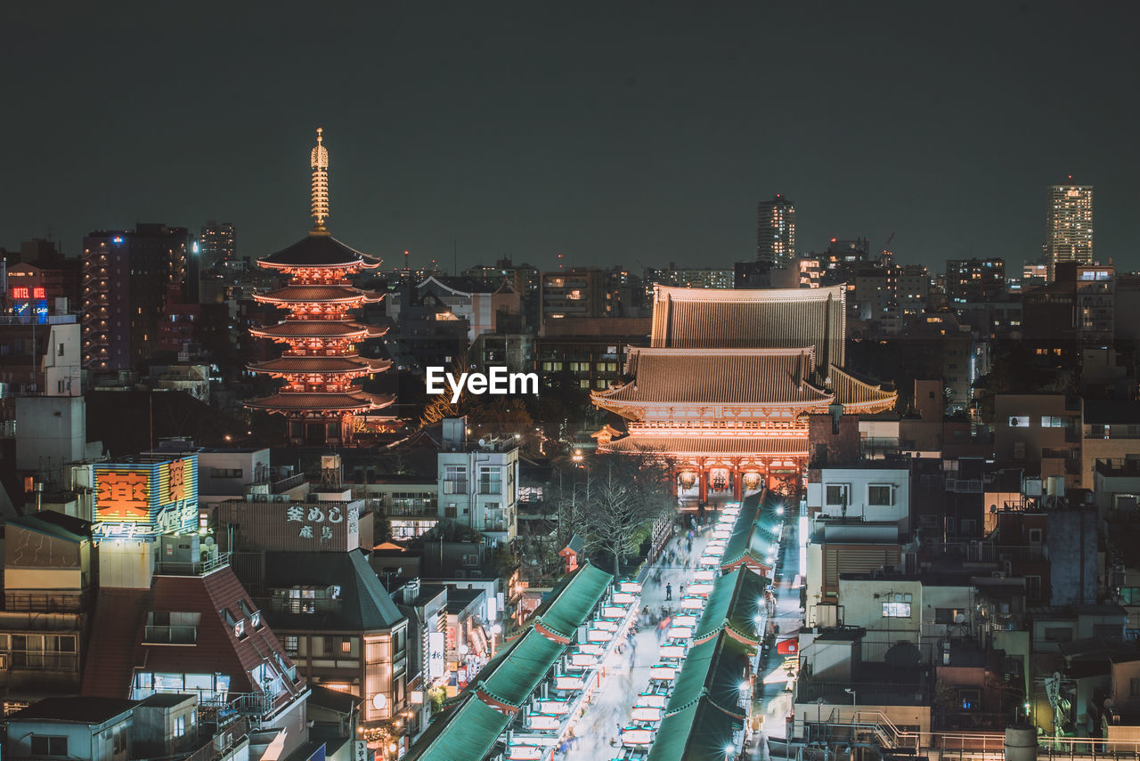 ILLUMINATED CITY BUILDINGS AT NIGHT