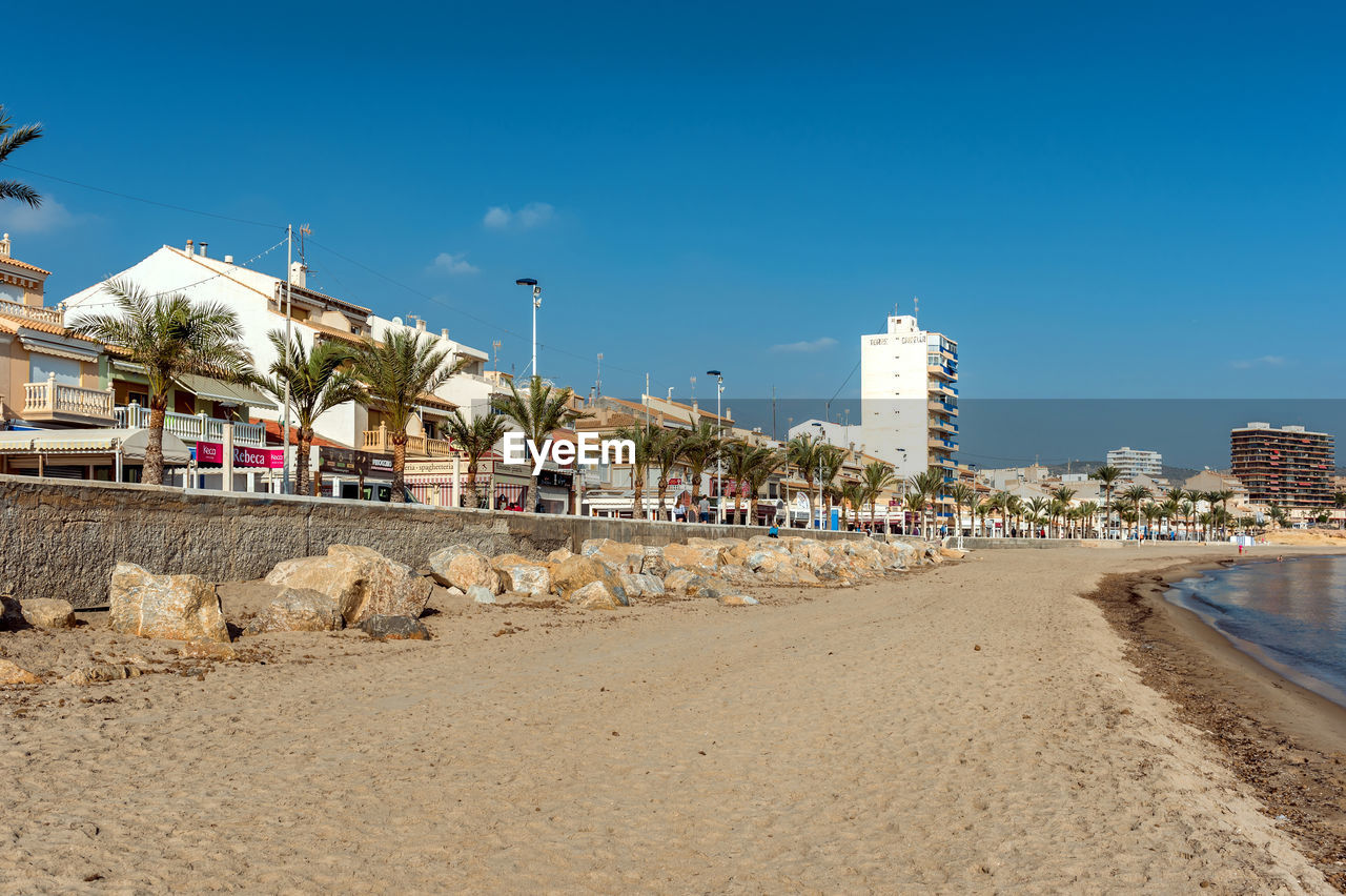 Tourist resort by costa blanca beach against sky