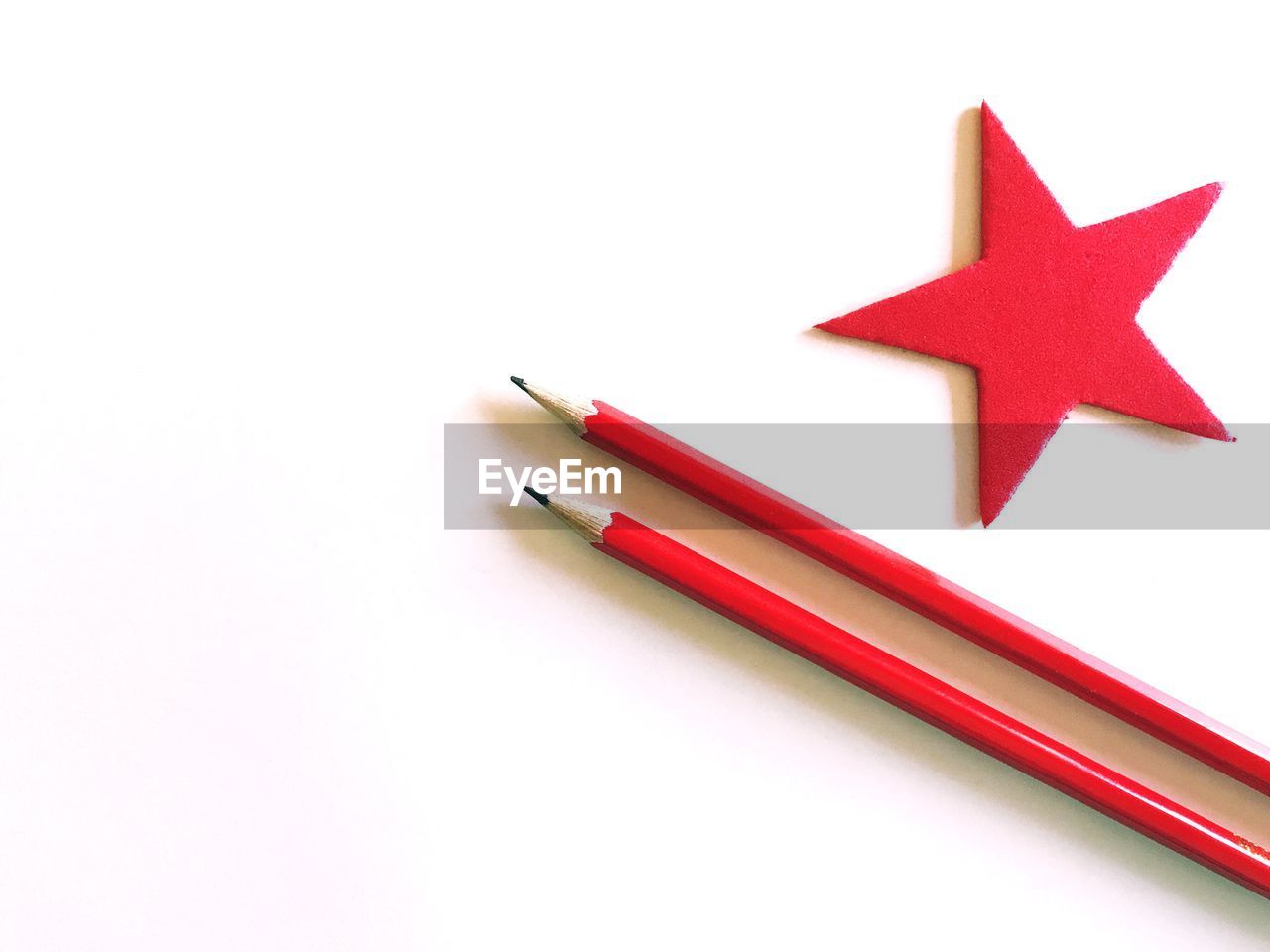 Directly above of pencils and star shape on white background