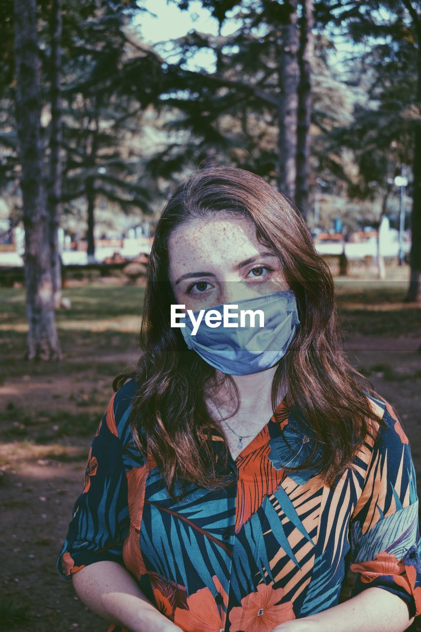 Portrait of young woman against trees