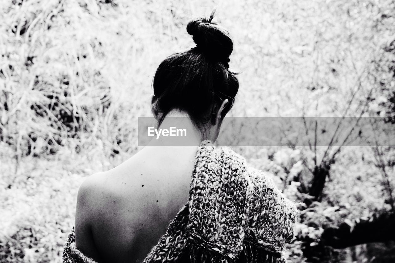 Rear view of woman with hair bun standing outdoors