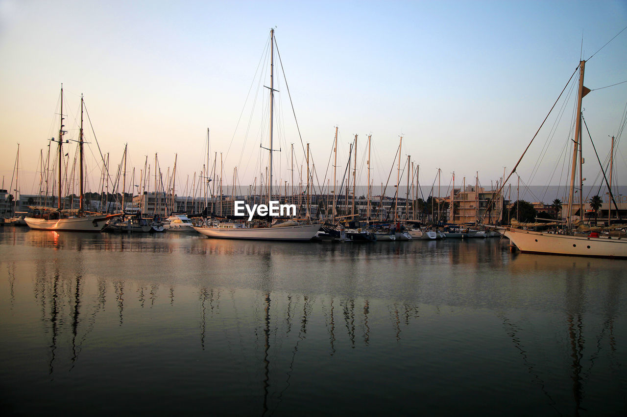 Sailboats moored at harbor