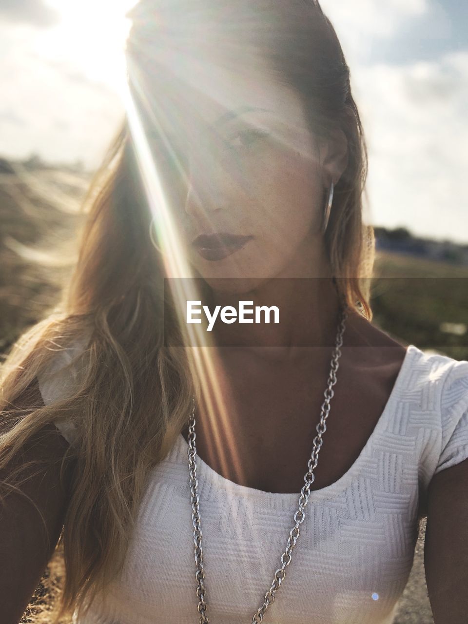 Portrait of beautiful young woman against sky