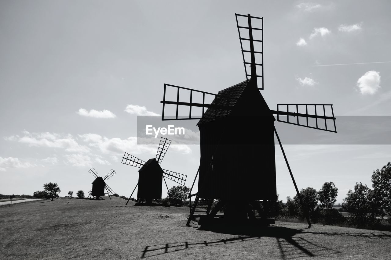 Traditional windmills on land against sky