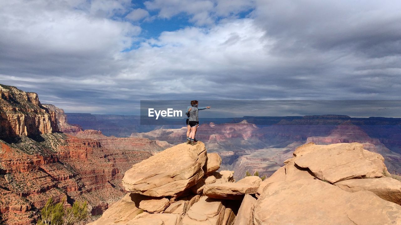 Tourists on rock formations against sky