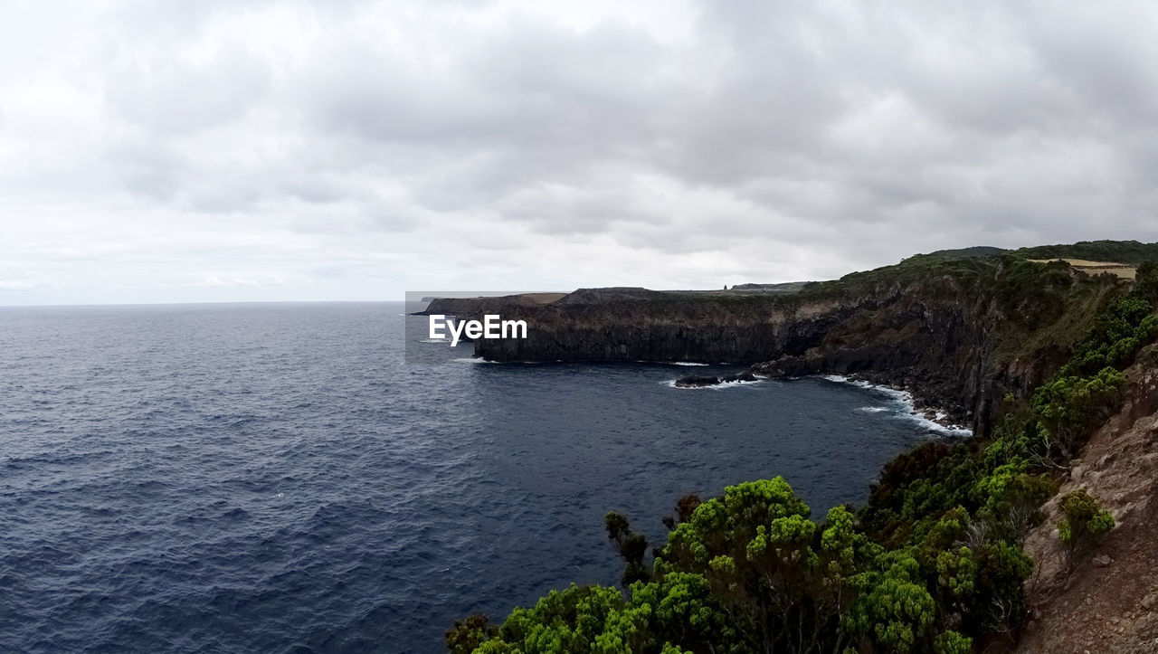 SCENIC VIEW OF SEA BY CLIFF AGAINST SKY