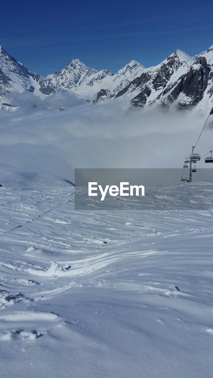 Scenic view of snow covered mountains against sky