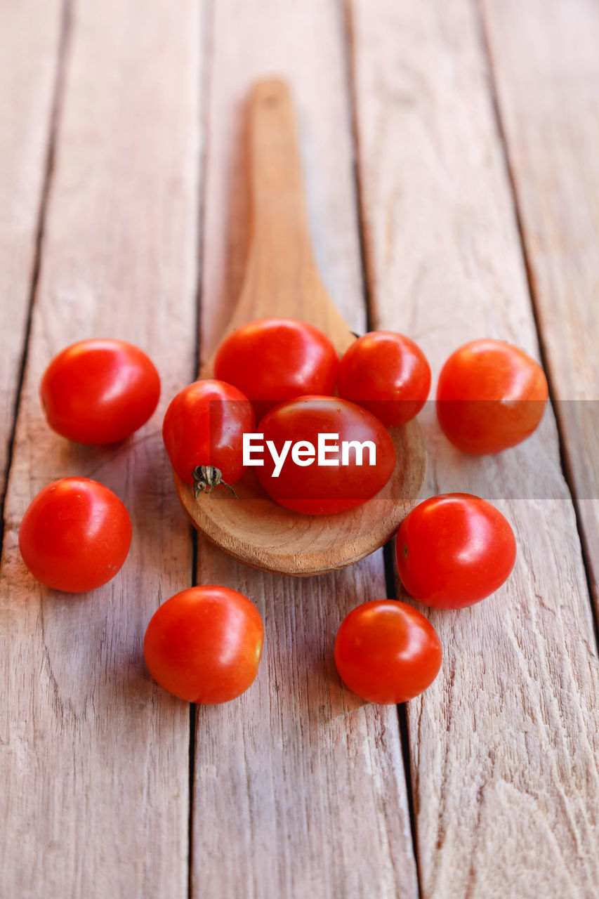 CLOSE-UP OF TOMATOES ON WOODEN TABLE