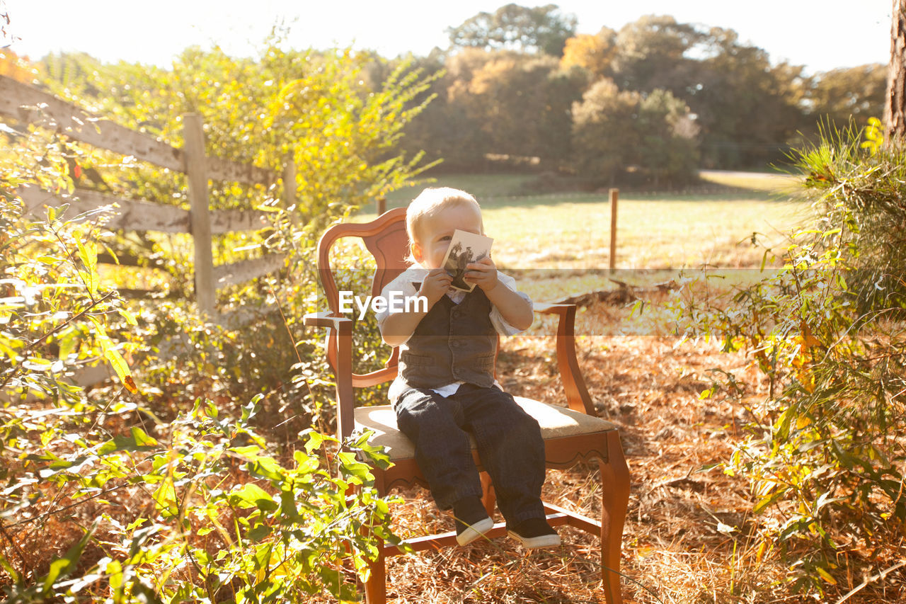 Boy sitting on chair at park