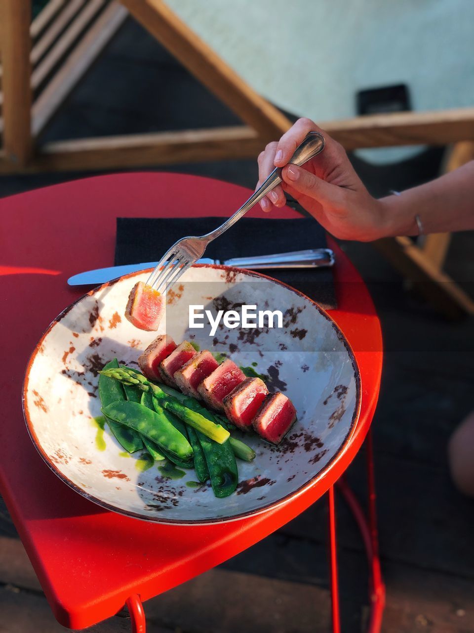 Cropped hand eating food on table