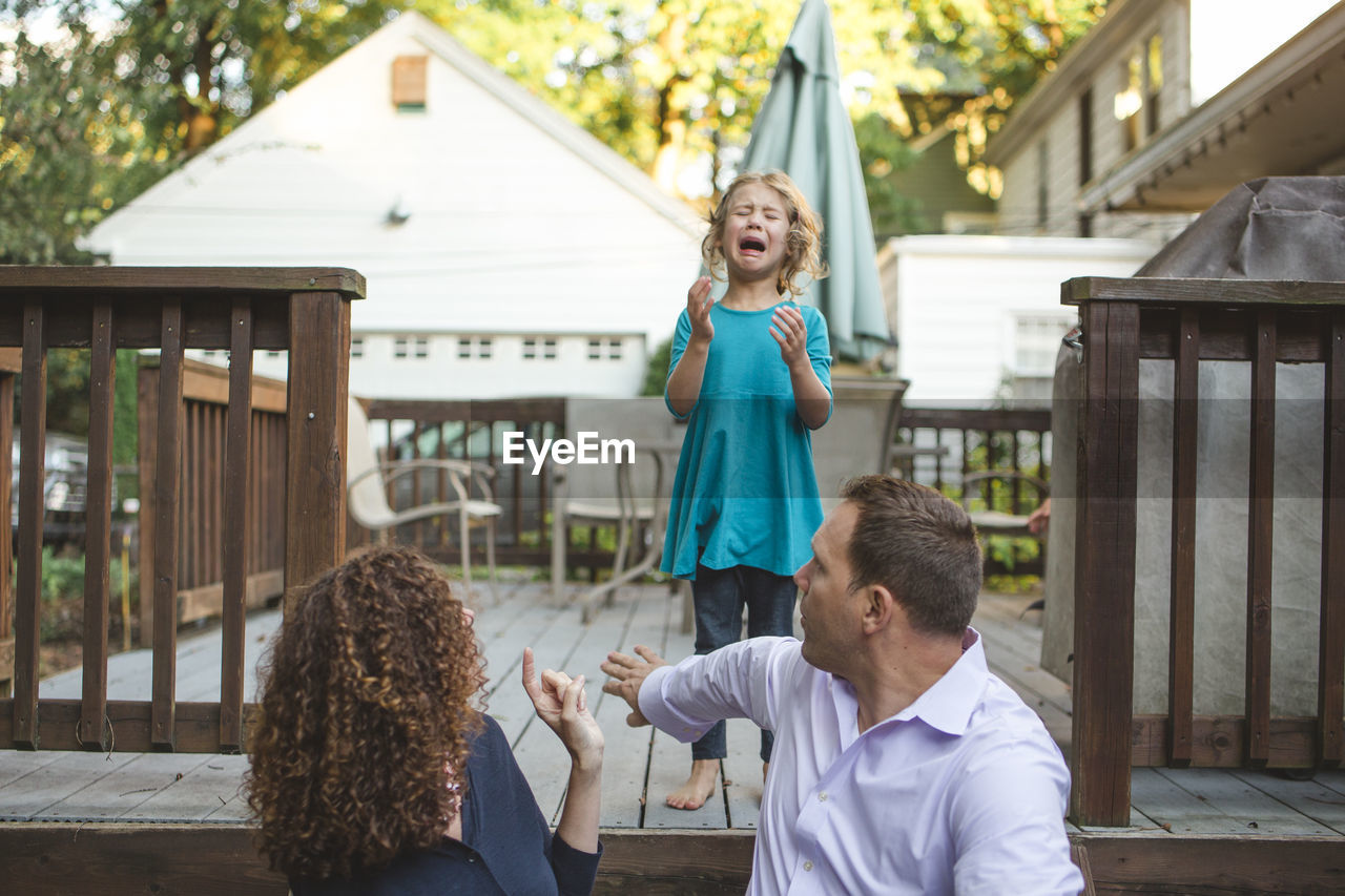 Parents admonish an unhappy crying little girl