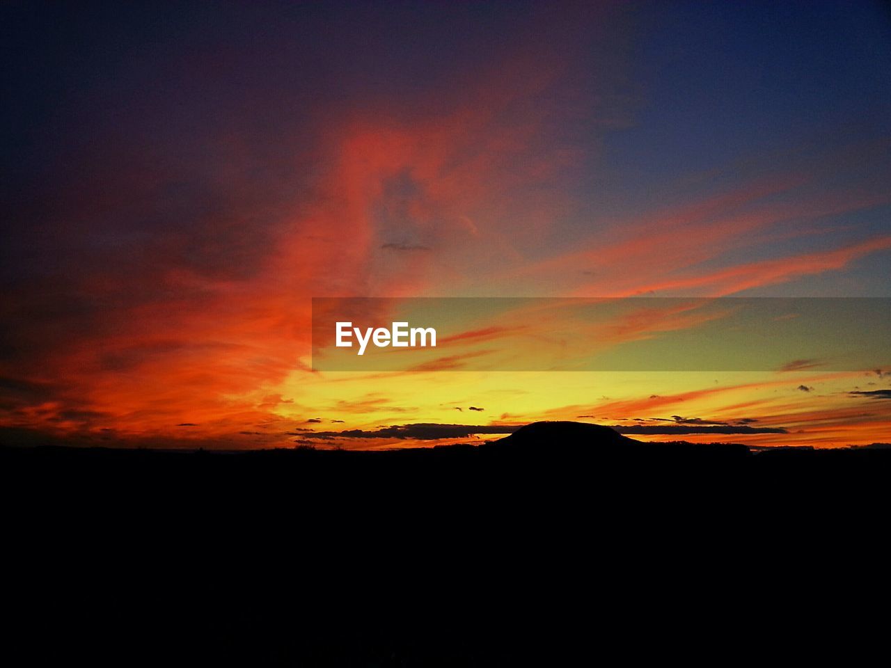 Silhouette landscape against scenic sky