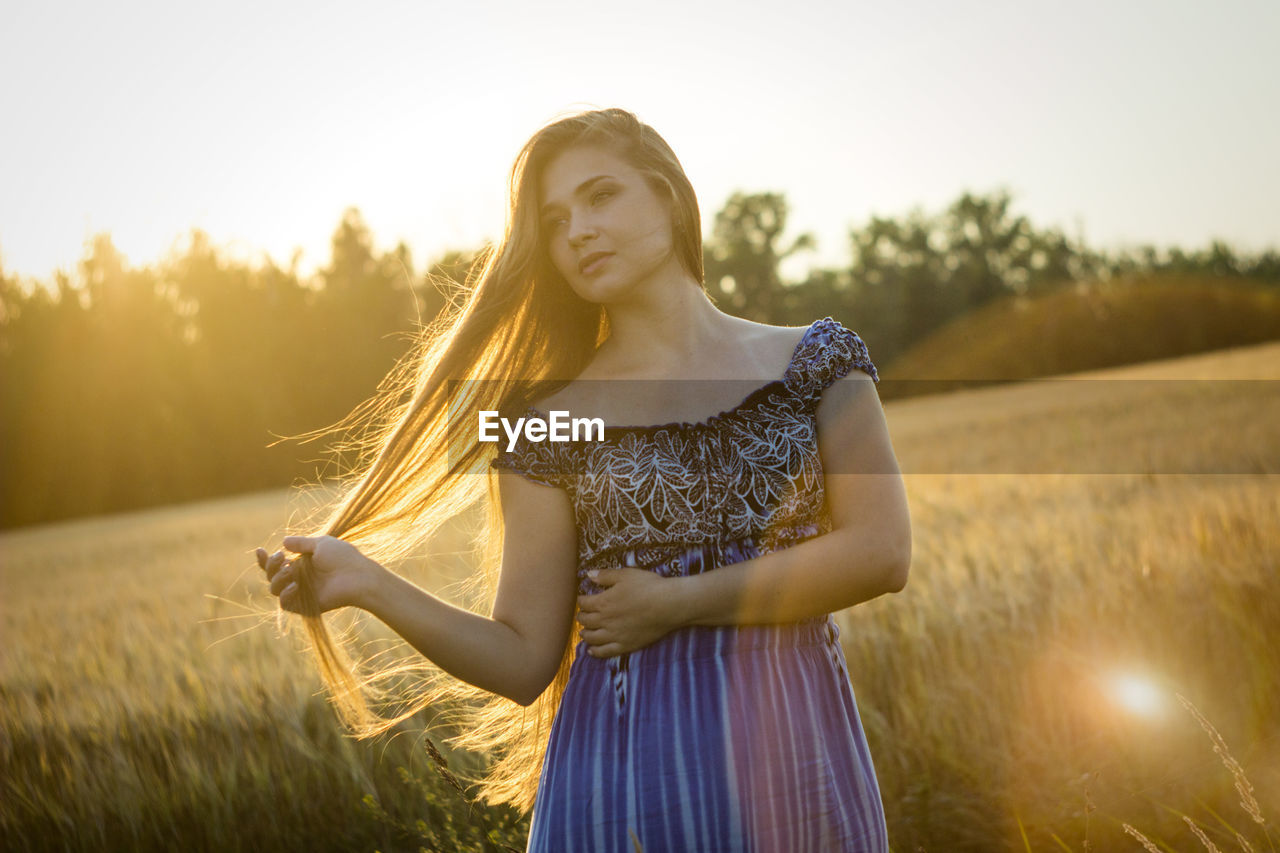 Woman standing on field against sky