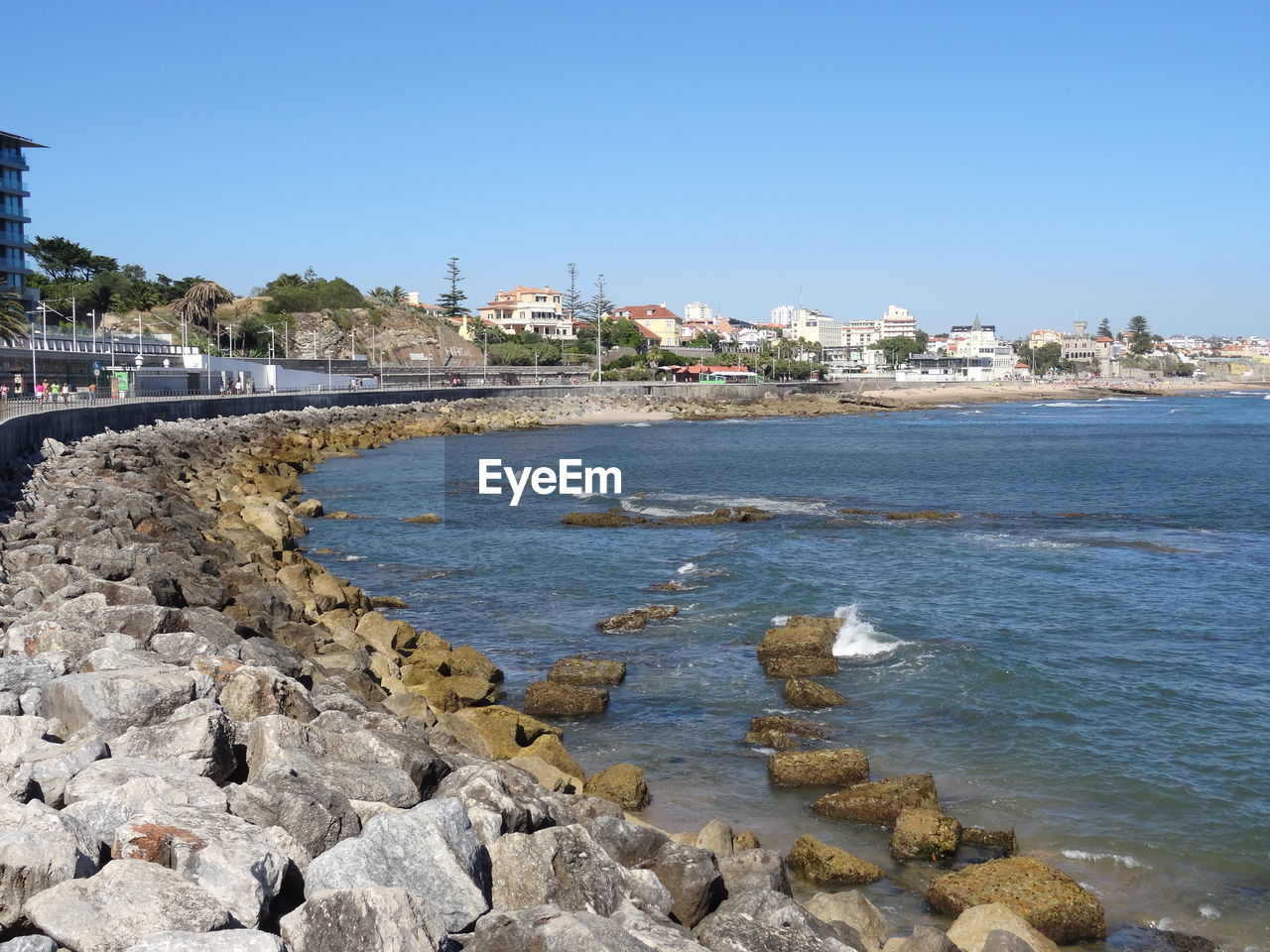 Scenic view of sea by buildings against clear sky