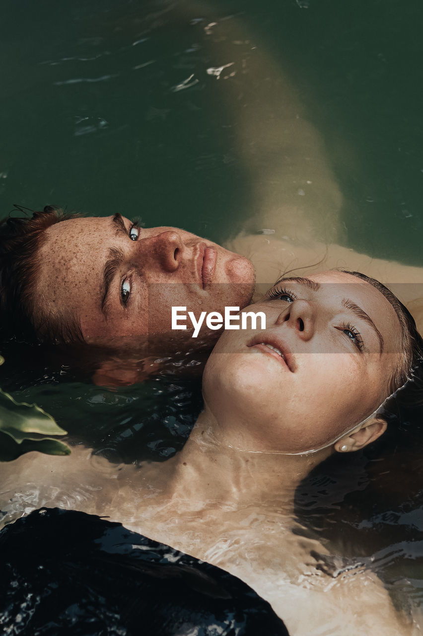 High angle view of couple floating on lake