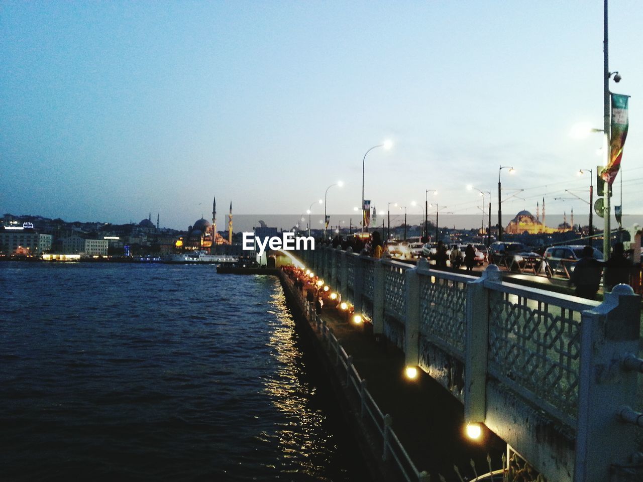 Illuminated bridge over river against sky