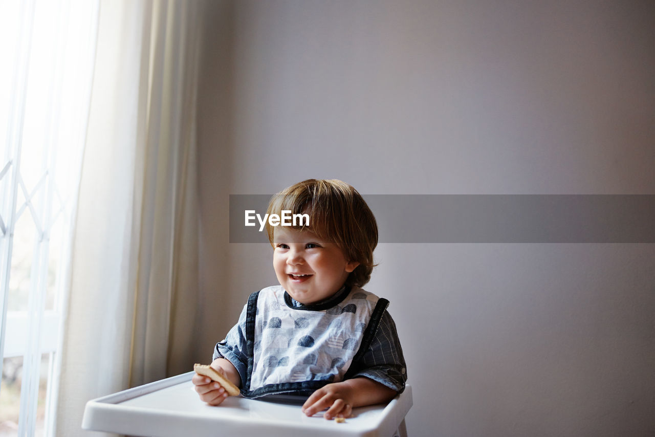 Portrait of cute boy sitting at home