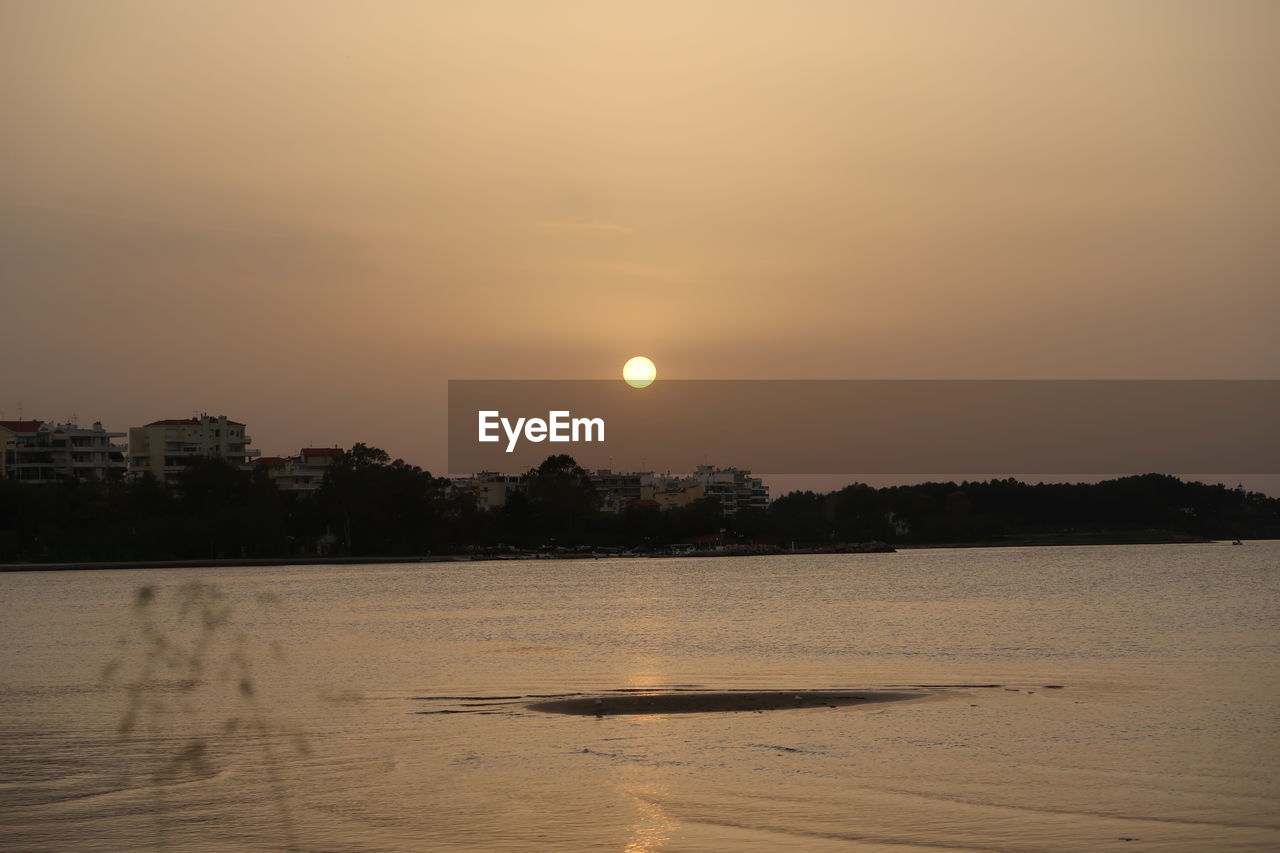 SCENIC VIEW OF LAKE AGAINST ORANGE SKY DURING SUNSET