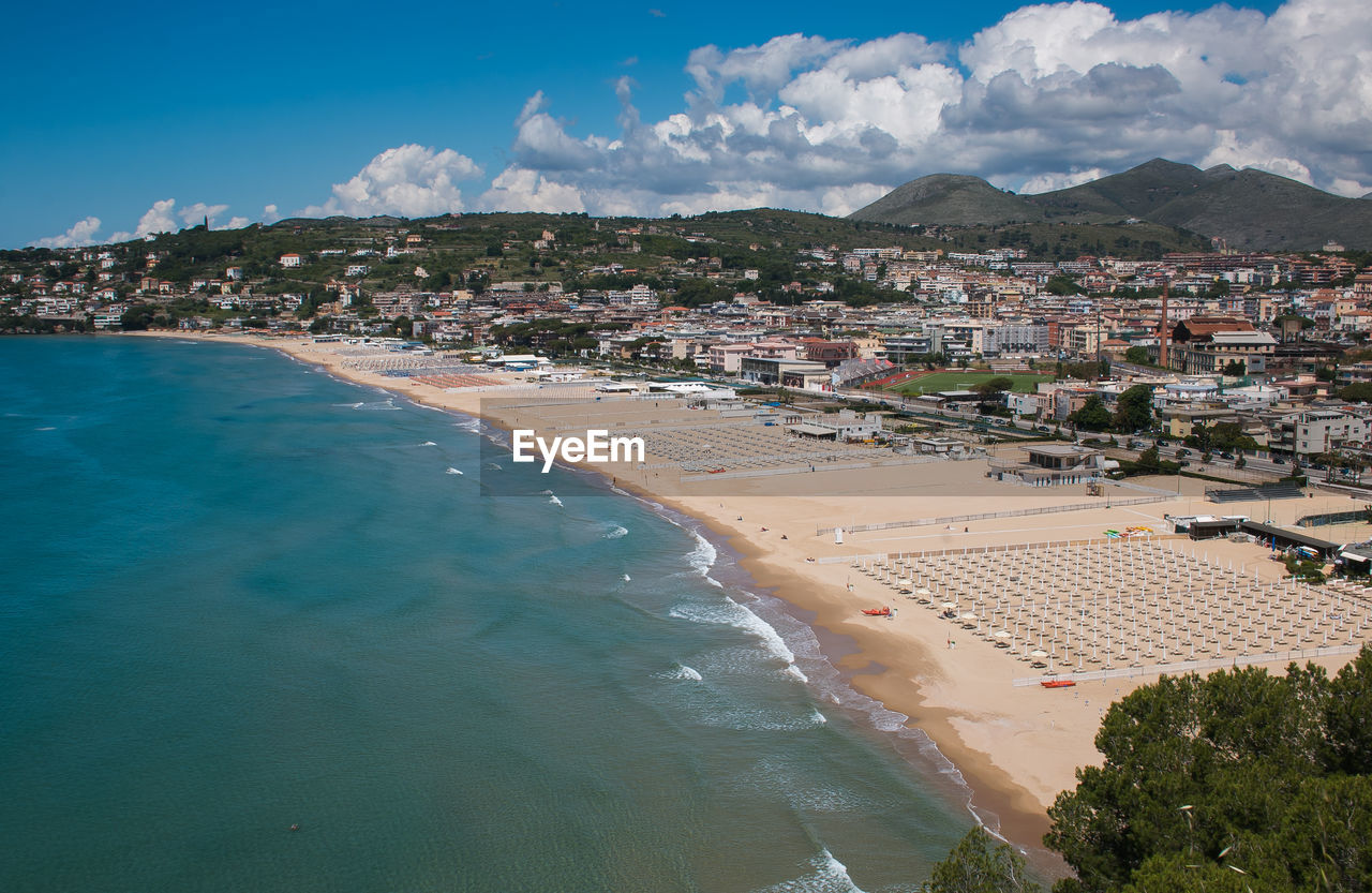 High angle view of townscape by sea against sky