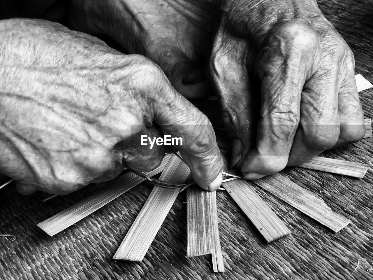 Cropped image of person weaving wicker