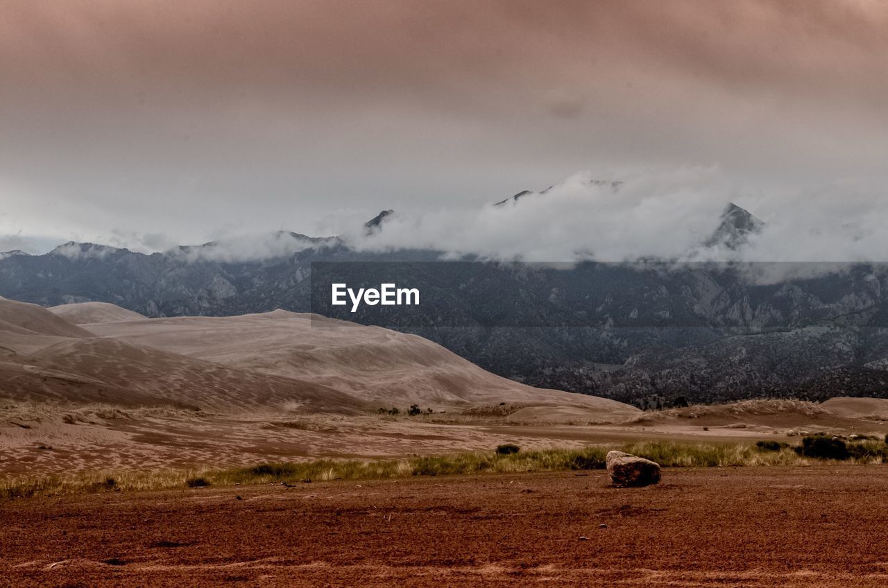 Scenic view of mountains against cloudy sky