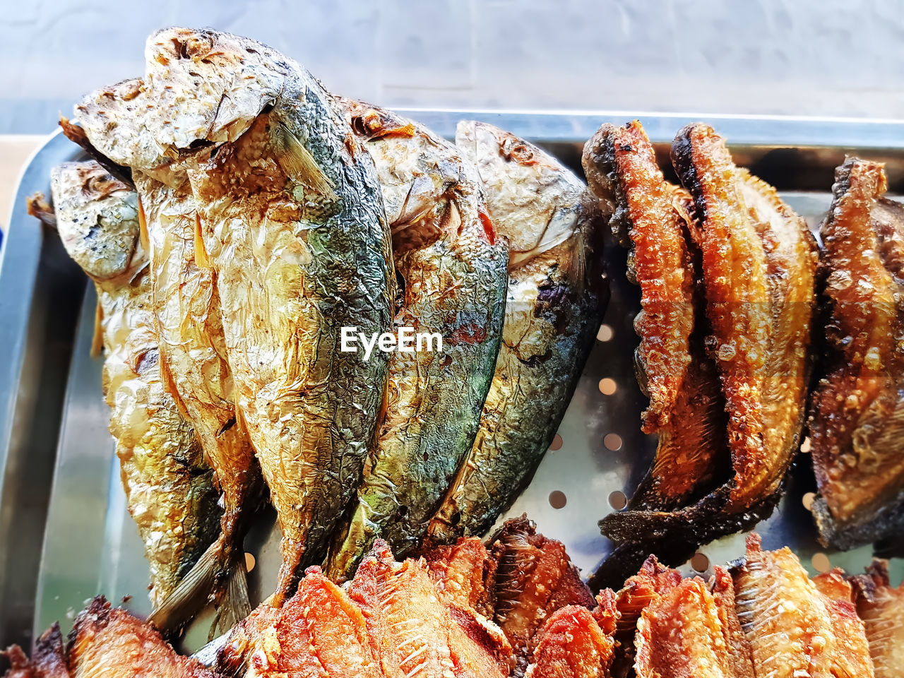 Fried mackerel and salted fish on stainless steel tray