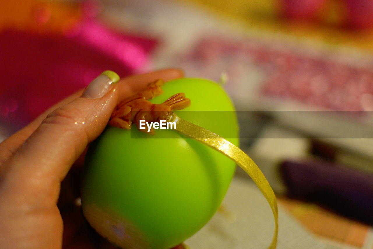 Cropped image of woman hand decorating easter egg