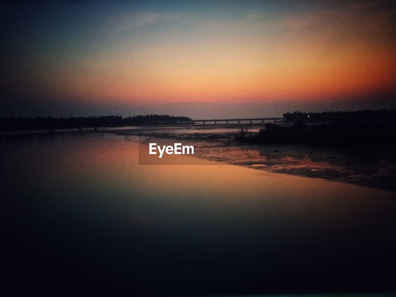 SCENIC VIEW OF BEACH AGAINST SKY AT SUNSET