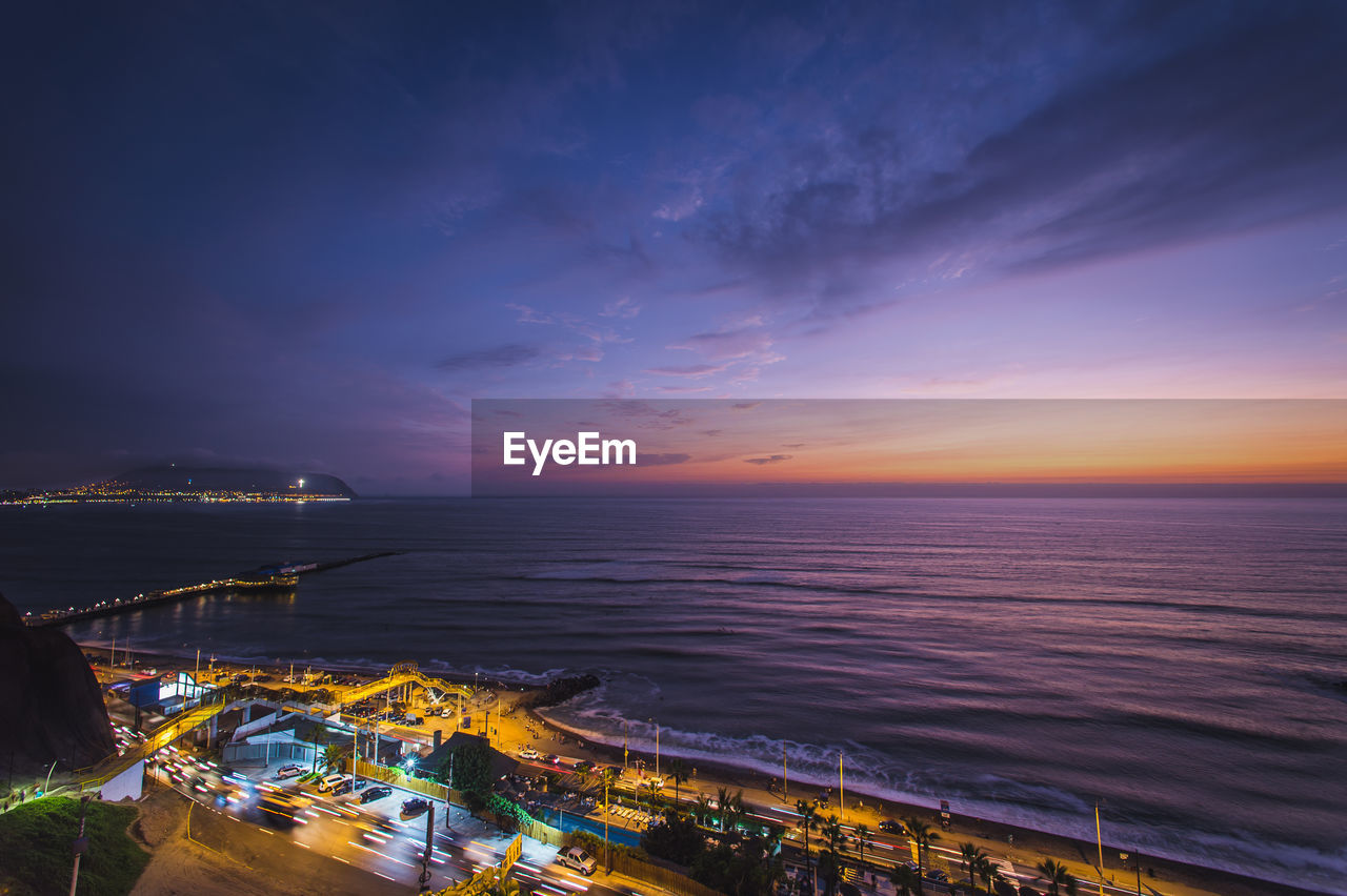 SCENIC VIEW OF BEACH AGAINST SKY AT SUNSET