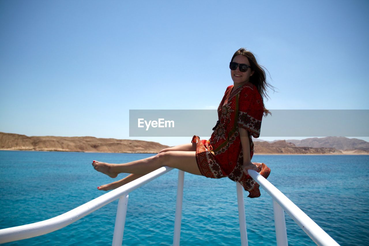 Woman sitting on railing