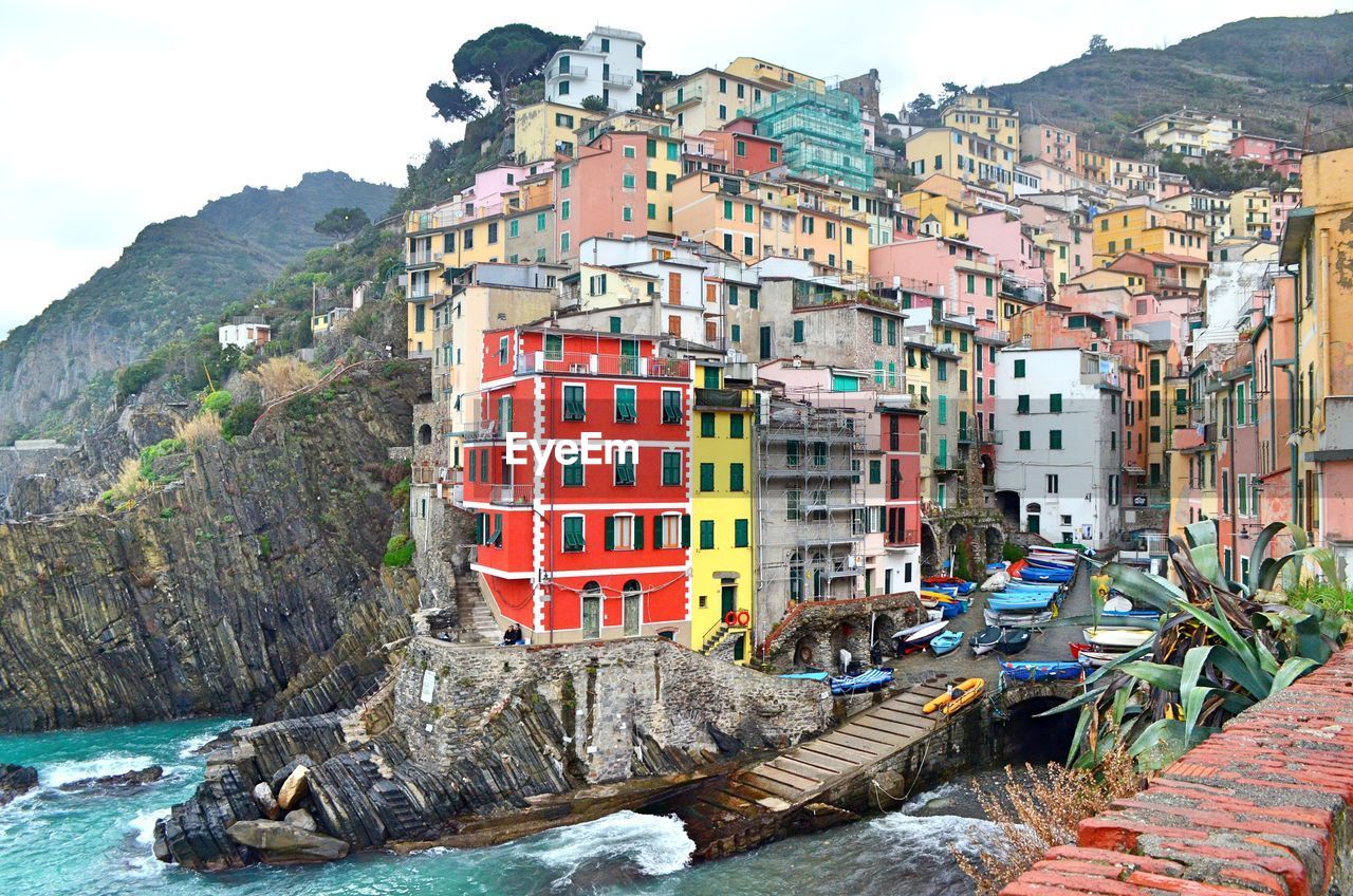 Residential buildings by mountain against sky