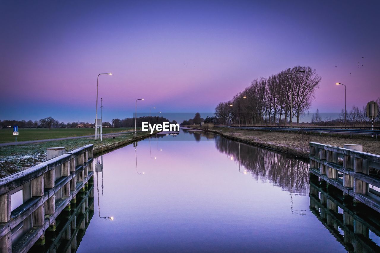 Scenic view of lake against sky at dusk